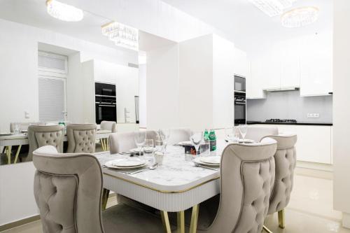 una sala da pranzo bianca con tavolo e sedie di Lé David City Apartments 1020 a Vienna