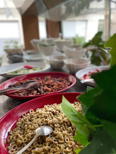 a table topped with plates of food with a spoon at Giritligil Hotel in Manisa