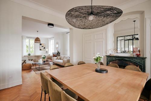 une salle à manger avec une table et un salon dans l'établissement Maison Martouret - Colodge, à Andrézieux-Bouthéon