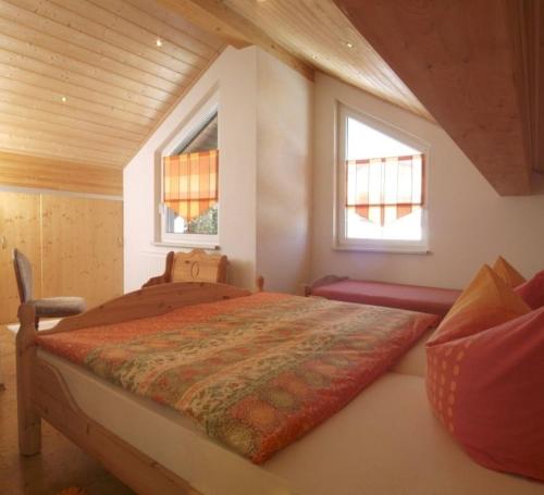 a bedroom with a large bed with two windows at Landhaus am Rennweg in Neuhaus am Rennweg