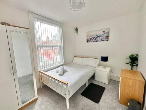 a bedroom with a bed and a large window at (S17) Convenient 2BR Leeds - Sleeps 4 in Leeds