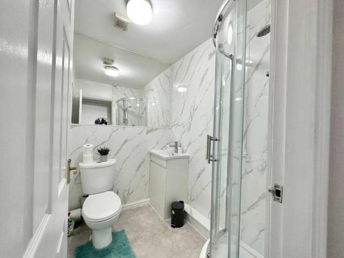 a white bathroom with a toilet and a shower at (S17) Convenient 2BR Leeds - Sleeps 4 in Leeds
