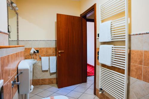a bathroom with a toilet and a wooden door at Panoramic Rooms Torre della Vittoria in Ferrara