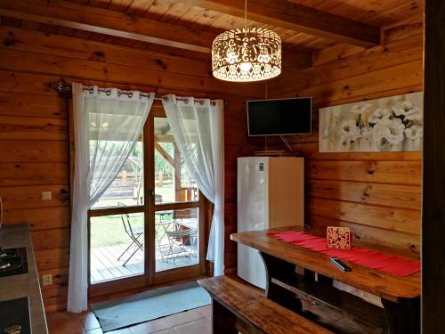 a kitchen with a refrigerator and a window in a cabin at Noclegi Gaja in Święta Katarzyna