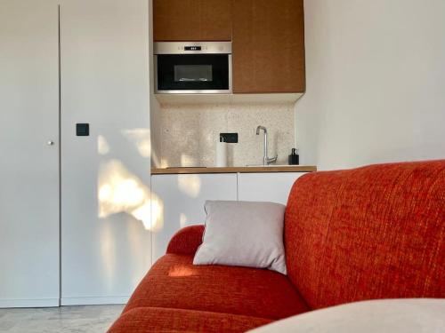 Cette chambre comprend un canapé rouge et un four micro-ondes. dans l'établissement Nîmes centre Superbe studio, à Nîmes