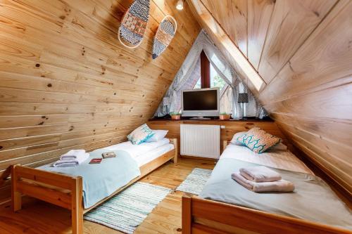 ザコパネにあるRent like home - Bulwary IIの木造キャビン内のベッドルーム1室(ベッド2台付)