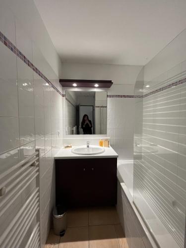 une salle de bain blanche avec un lavabo et un miroir dans l'établissement Residence Cap Bleu a Carro, à Martigues