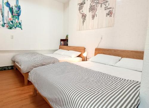 安平的住宿－台南 古堡民宿 - 可包棟 含電動麻將 switch，两张睡床彼此相邻,位于一个房间里