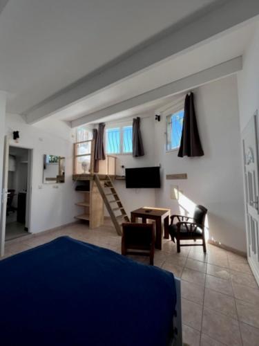 un salon avec un lit, une table et des chaises dans l'établissement Cosy T2 les pieds dans la mer, à Martigues