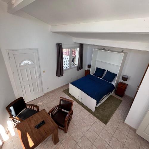 une chambre avec un lit, une chaise et une table dans l'établissement Cosy T2 les pieds dans la mer, à Martigues