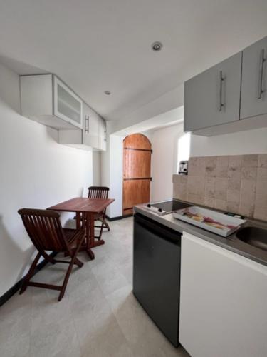 une cuisine avec une table en bois et une tableastery ... dans l'établissement Cosy T2 les pieds dans la mer, à Martigues