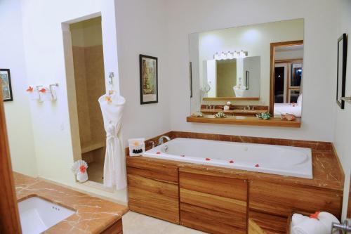 a bathroom with a large tub and a large mirror at The Phoenix Resort in San Pedro