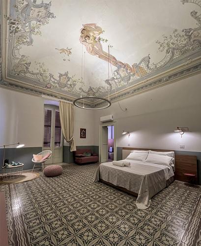 1 dormitorio con 1 cama y techo con pinturas en B&B Palazzo 1906 - Eco dimora storica, en Bitetto