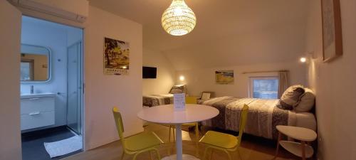 a room with a bed and a table and chairs at B&B Les Lits de Nohaipré in Rendeux
