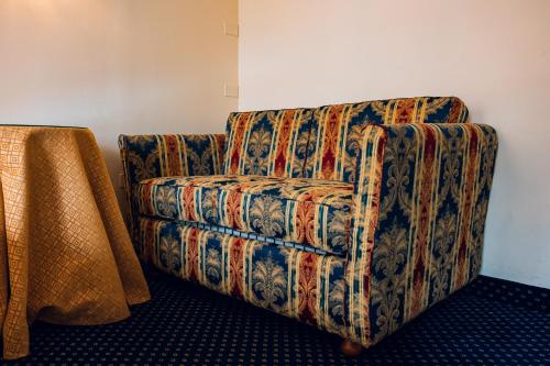 a colorful couch sitting in a room with a table at Panoramic Rooms Torre della Vittoria in Ferrara