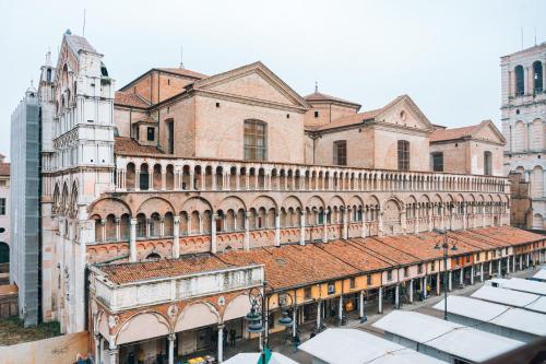 an old building with a red roof in a city at Panoramic Rooms Torre della Vittoria in Ferrara