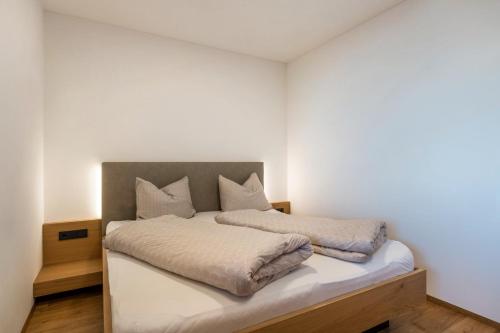 ein Schlafzimmer mit einem großen Bett mit weißer Bettwäsche in der Unterkunft Ferienwohnungen Karin - Merlot in Tramin an der Weinstraße