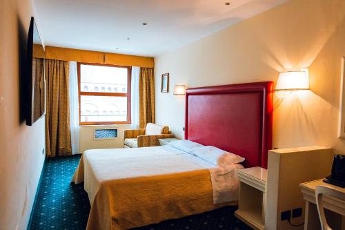 a hotel room with a bed and a chair at Panoramic Rooms Torre della Vittoria in Ferrara