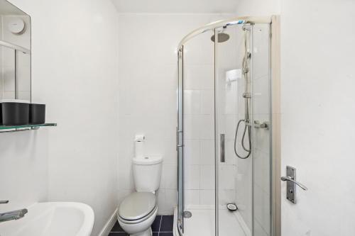 a bathroom with a toilet and a glass shower at Boutique Apartments in Central Bristol in Bristol