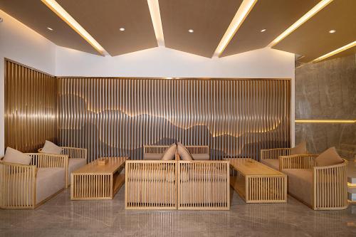 a lobby with wicker chairs and tables in a room at Moon River View Hotel in Fenghuang