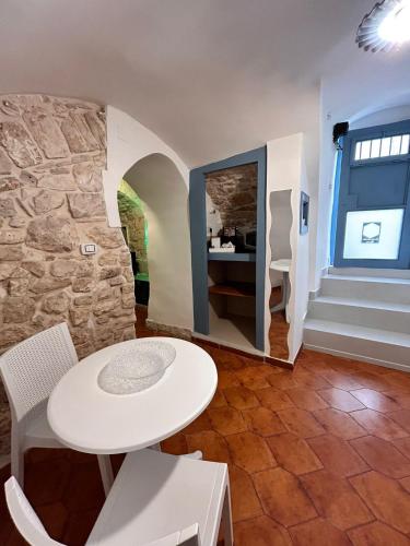 a table and chairs in a room with a stone wall at GEOMETRIC BLUE in Casamassima