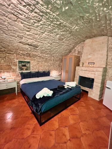 GEOMETRIC BLUE في كاساماسيما: غرفة نوم مع سرير في غرفة حجرية