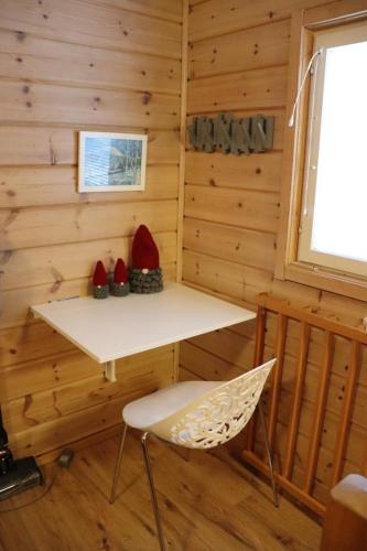 a room with a table and a chair in a cabin at Ylläs slope SareStar in Ylläsjärvi
