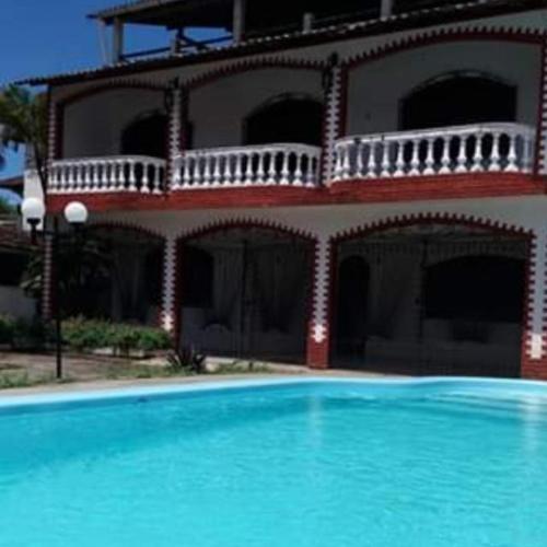 a building with a swimming pool in front of a house at Casarão Farol da Marise Sol in Belém