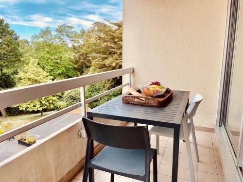 uma mesa numa varanda com uma cesta de frutas em Un nid dans les pins La Baule em La Baule