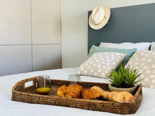 - un plateau de pain et des verres à vin sur le lit dans l'établissement Un nid dans les pins La Baule, à La Baule