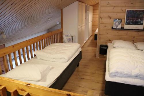 - 2 lits dans une chambre dotée de murs en bois dans l'établissement Ylläs slope SareStar, à Ylläsjärvi