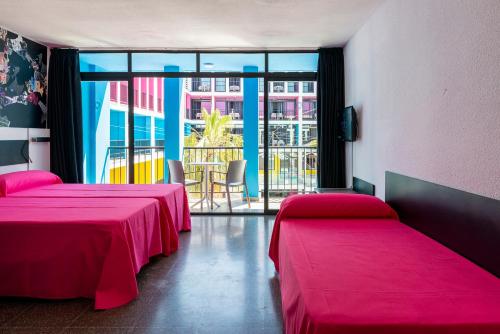 a room with two beds and a large window at Ibiza Rocks Hotel - Adults Only in San Antonio