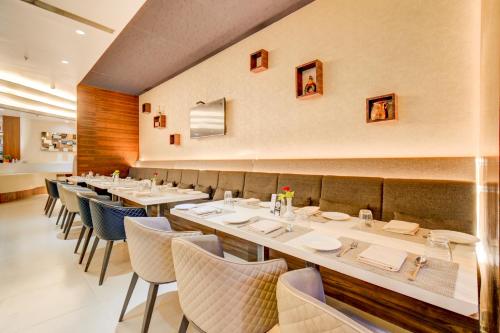 a dining room with white tables and chairs at The SSK Solitaire Hotel & Banquets in Nashik