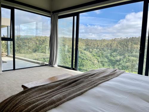 1 dormitorio con 1 cama frente a una ventana grande en Hilltop 39 House, Oubaai Golf Estate, en Herolds Bay