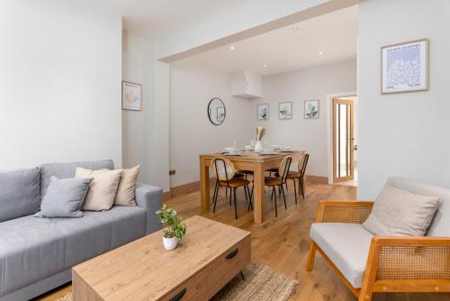 een woonkamer met een bank en een tafel bij Flatzy - Stunning Home by Lark Lane with Pool Table in Liverpool