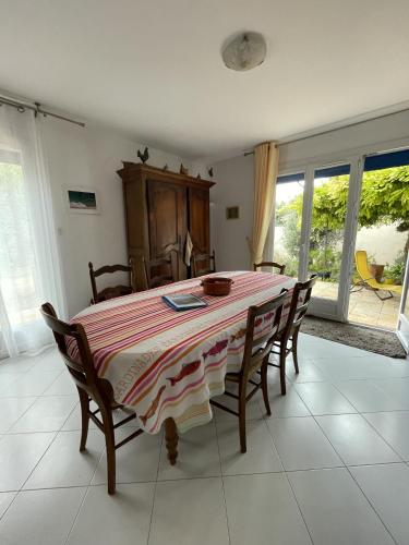 une table à manger avec des chaises et un tissu de table rayé dans l'établissement Villa Provencale au bord de mer, à Martigues