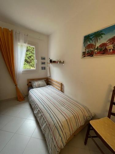 een kleine slaapkamer met een bed en een raam bij Villa Provencale au bord de mer in Martigues
