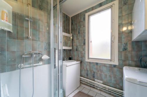 een badkamer met een douche, een toilet en een wastafel bij Florévasion - Appt pour 5 in Bobigny