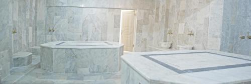 ein weißes Bad mit einer Badewanne und einem WC in der Unterkunft Blue Sea Hotel & Spa in Kusadası