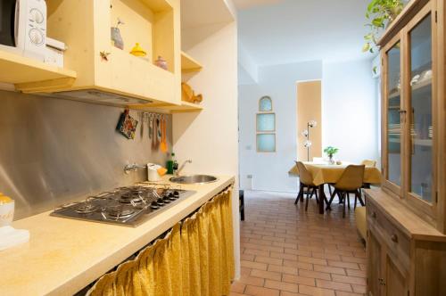 cocina con fogones horno superior junto a una mesa en Urban Retreat - AmbrogioHost, en Bolonia