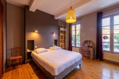 1 dormitorio con 1 cama grande, mesa y sillas en Le Clos Lamouroux - Grande maison pour 12 en Agen