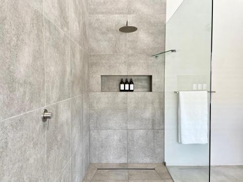 baño con ducha y puerta de cristal en Hilltop 39 House, Oubaai Golf Estate, en Herolds Bay