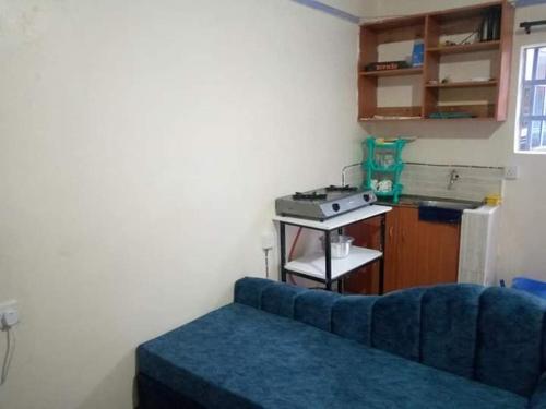 a living room with a blue couch and a stove at Atiram furnished apartments in Nakuru