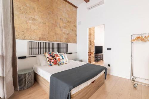 a bedroom with a bed and a brick wall at PR27 in Valencia