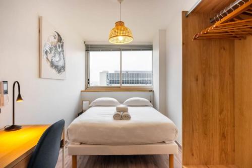 une chambre avec un lit, un bureau et une fenêtre dans l'établissement Le Prouvé * Parking Privé Inclus, à Nancy
