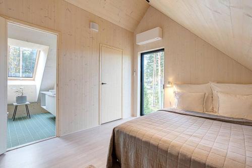 a bedroom with a large bed and a bathroom at Villa Pickala - Design - Seafront - Hot tub in Helsinki
