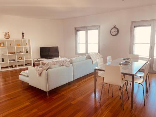 uma sala de estar com um sofá branco e uma mesa em Expo Luxury apartment em Lisboa