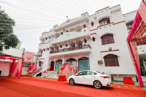 a white car parked in front of a building at J C Guest House in Hasanganj