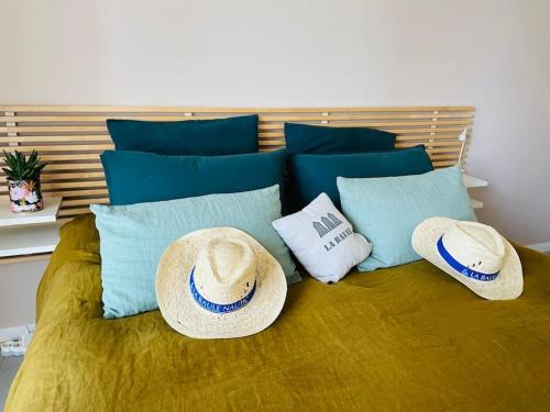 two hats and pillows on top of a bed at L'Hallali à la Baule centre in La Baule