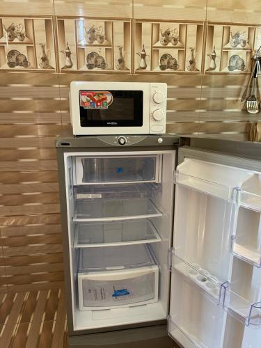 uma cozinha com um frigorífico aberto e um micro-ondas em Jabal Shams, the summit house em Misfāh
